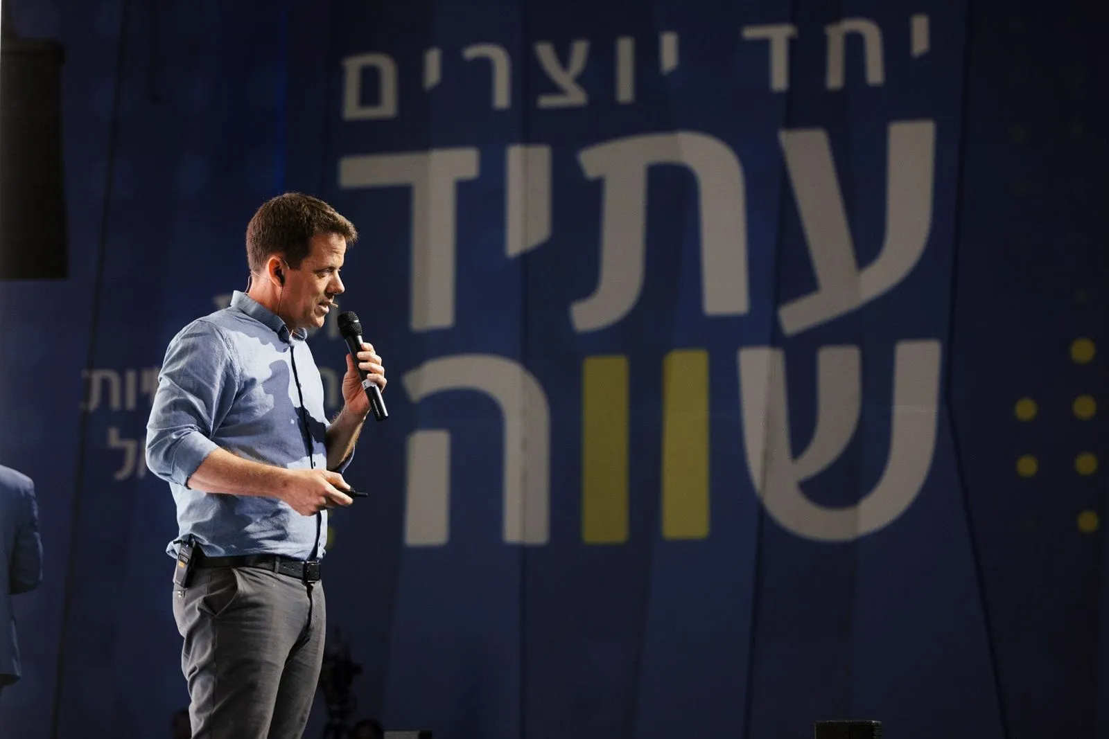 תום הגלעדי מרצה על הבמה בכנס של קרן רש"י